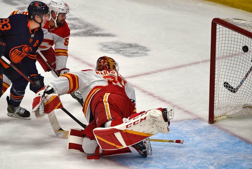 Edmonton Oilers forward Ryan Nugent-Hopkins scores the eventual game-winner on Calgary Flames goalie Jacob Markstrom while battling defenceman Oliver Kylington during Game 4 of their second-round playoff series 
at Rogers Place in Edmonton on May 24, 2022.