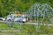 A massive hydro tower lies crumpled in half along Highway 417 near Hunt Club Road as crews continue to try to restore power on Monday. 
