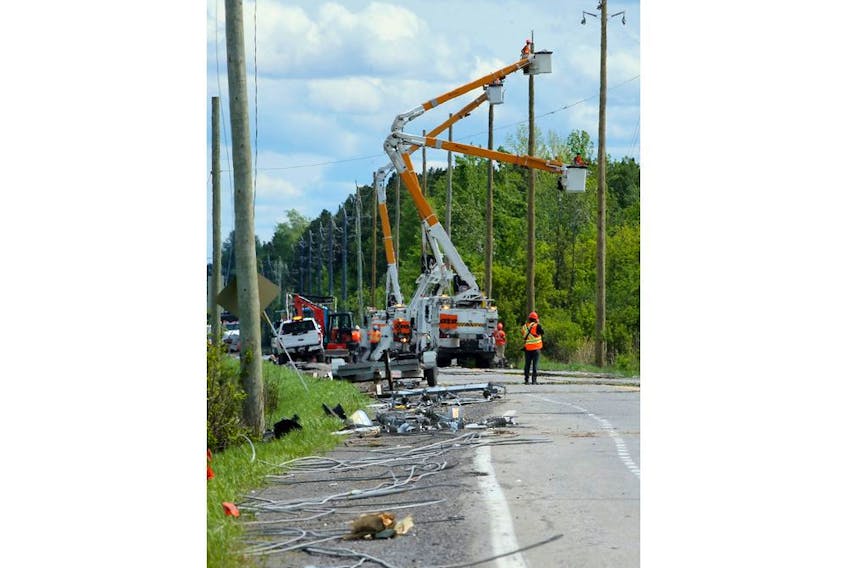 Crews work to restore power at downed hydro poles along Hawthorne Avenue, which remained closed to traffic near Hunt Club Road Monday. 
