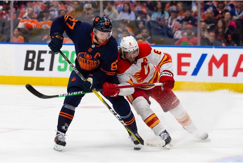 EDMONTON, AB - MAY 24: Connor McDavid #97 of the Edmonton Oilers is defended by Christopher Tanev #8 of the Calgary Flames during the second period in Game Four of the Second Round of the 2022 Stanley Cup Playoffs at Rogers Place on May 24, 2022 in Edmonton, Canada.