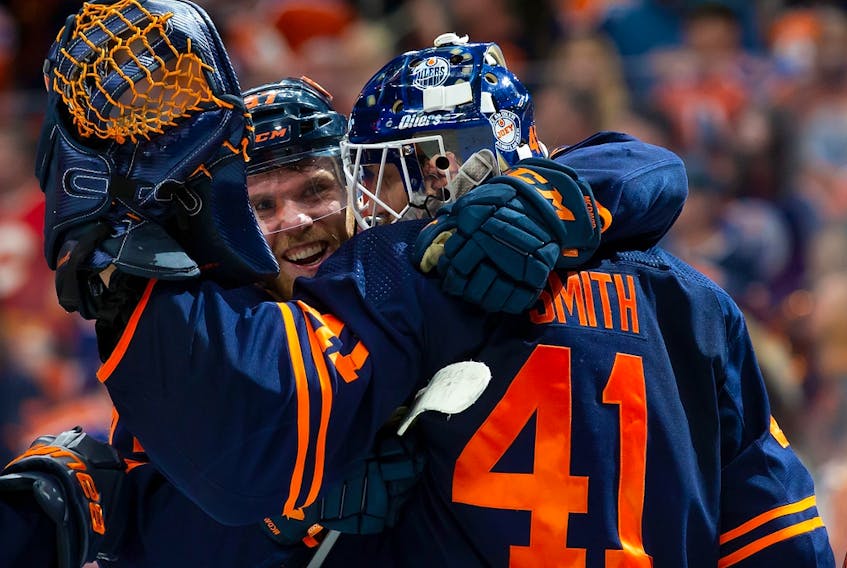 Connor McDavid (97) and goaltender Mike Smith (41) of the Edmonton Oilers celebrate their victory against the Calgary Flames in Game 4 of their Stanley Cup playoff series at Rogers Place on May 24, 2022, in Edmonton.
