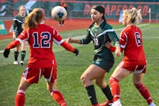 Alliyah Rowe of the Cape Breton Capers, middle, battles for the ball with Meghan Johnston, left, and Rebecca LeBlanc of the Acadia Axewomen during Atlantic University Sport women’s semifinal action at the Ness Timmons Turf Field in Sydney. The Capers will begin their 2022 AUS season in September. JEREMY FRASER/CAPE BRETON POST.