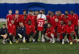 The Canadian mens national soccer team poses for a picture with Prime Minister Justin Trudeau during a practice at the Edmonton Soccer dome on Monday, Nov. 15, 2021 in Edmonton. 