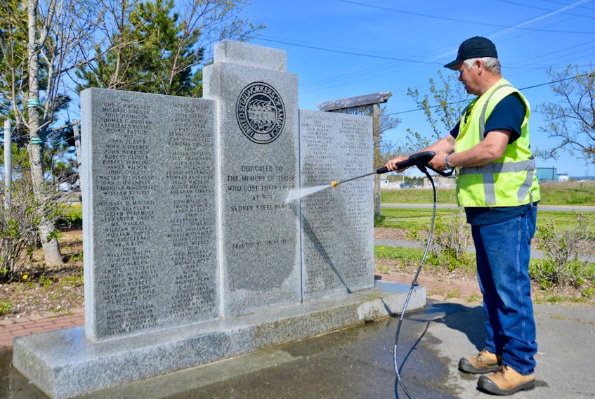 Former steelworker and current Nova Scotia Lands employee Steve Gillis uses a high-pressure washer to clean the moss off the memorial dedicated to workers who lost their lives at the Sydney steel plant. Gillis was joined at the memorial, located in Open Hearth Park on the site of the once massive operation, by another former steelworker, Gordie Buist. Buist's uncle Ernie Buist worked in the plant’s industrial relations division and turned 104 last week. DAVID JALA/CAPE BRETON POST