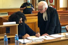 Stephen Hopkins (left), who is self-representing at trial at Newfoundland and Labrador Supreme Court in St. John's on charges of breaking into a home and confining, sexually assaulting and threatening a teenage girl who lived there, speaks with amicus curiae John Brooks in the courtroom May 27, 2022.
