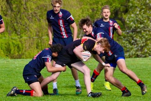 Kaden Smith and Wyatt Carling tackle a charging Horton high schooler while Zach Logan and Lukas Schmidt get in position to provide backup to their teammates during the regional rugby final on May 19.