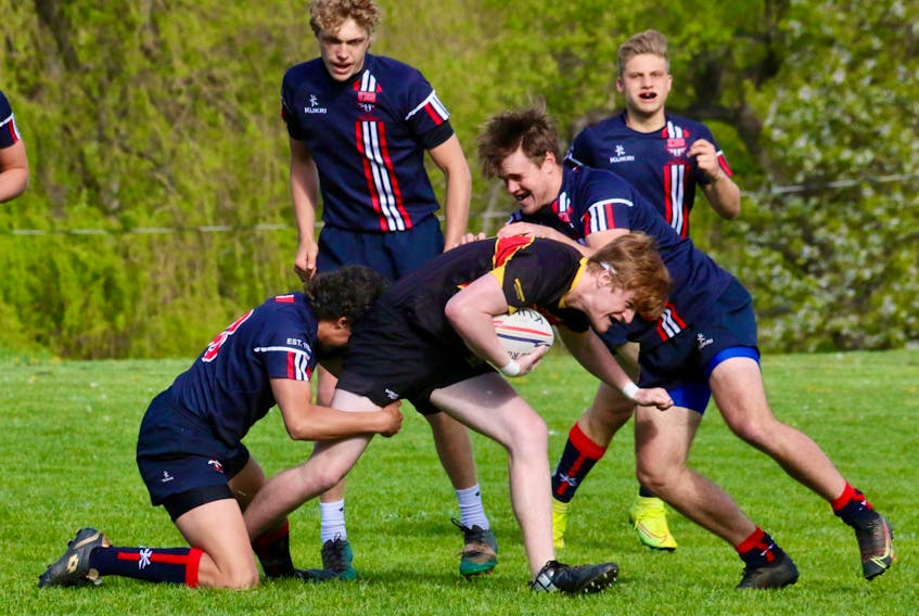 Kaden Smith and Wyatt Carling tackle a charging Horton high schooler while Zach Logan and Lukas Schmidt get in position to provide backup to their teammates during the regional rugby final on May 19.