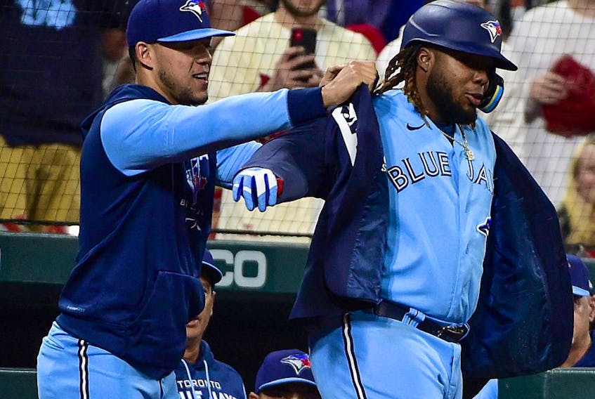 Toronto Blue Jays first baseman Vladimir Guerrero Jr. (right) receives the blue jacket from pitcher Jose Berrios after hitting a solo home run against the St. Louis Cardinals at Busch Stadium on May 24, 2022.

