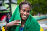  A thrilled Gelete Burka wraps herself in the Ethiopian flag at the marathon finish line in 2018. Ashley Fraser/Postmedia