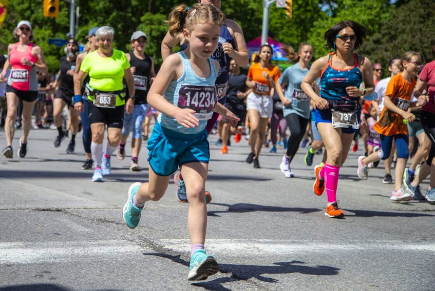 Runners, including Grace Clarke, take off from the start line of the 2K race at Tamarack Ottawa Race Weekend on Saturday.