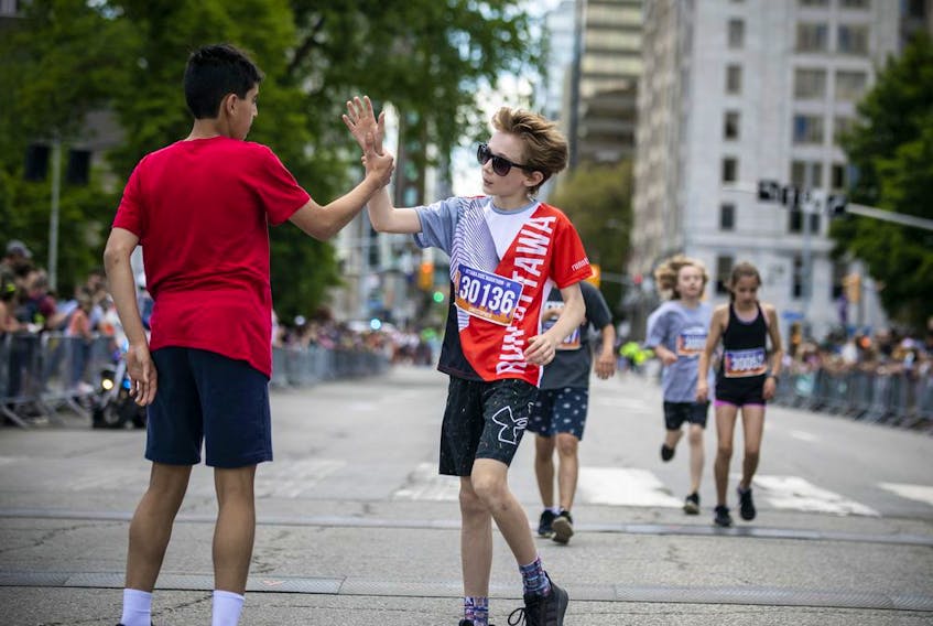 Mohamed Elhage, left, celebrates his first-place finish in the Kids Marathon with the second-place finisher, Christopher Burke-Terreau, right.