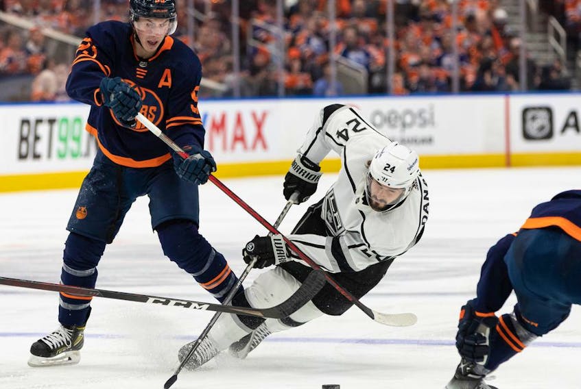 Edmonton Oilers' Ryan Nugent-Hopkins (93) trips up L.A. Kings' Phillip Danault (24) for a penalty during second period of NHL playoff action at Rogers Place in Edmonton, on Monday, May 2, 2022. Photo by Ian Kucerak