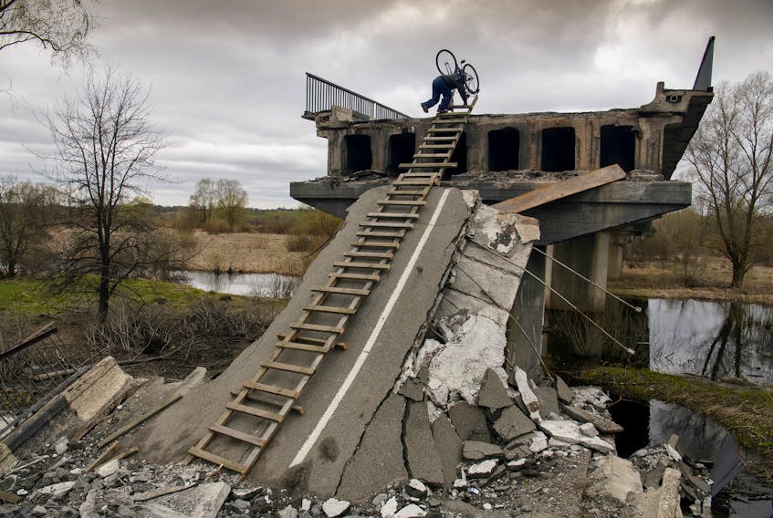 A local resident Mykola, 70, climbs down with a stepladder from a bridge destroyed during Russia's invasion in the village of Kukhari in Kyiv region, Ukraine April 19, 2022.  REUTERS/Vladyslav Musiienko     TPX IMAGES OF THE DAY  A local resident, Mykola, 70, climbs down from a bridge that was destroyed during Russia's invasion in the village of Kukhari in Kyiv region, Ukraine, on April 19, 2022. REUTERS/Vladyslav Musiienko