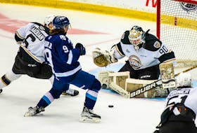 Charlottetown Islanders goaltender Franky Lapenna tracks the puck while defenceman Noah Laaouan, 6, and Sherbrooke Phoenix forward Stéphane Huard Jr., 9, battle for position in front. The action took place during Game 3 of the best-of-five Quebec Major Junior Hockey League semifinal series in Sherbrooke, Que., on May 29. The Islanders won the game 3-2 to take a 2-1 series lead. Sherbrooke Phoenix • Vincent L-Rousseau