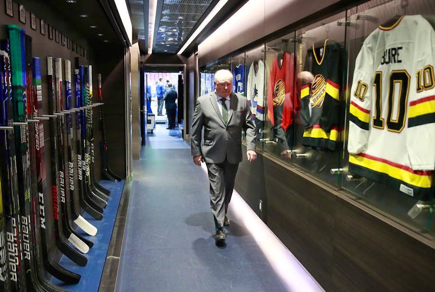 Head coach Bruce Boudreau of the Vancouver Canucks walks past the dressing room.