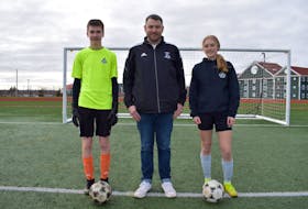 Cape Breton FC soccer players Ciaran MacDonald, left, and Julia Mombourquette, right, are pictured with Soccer Cape Breton president Will Van Hal at the Ness Timmons Turf Field in Sydney. Cape Breton FC will return to the outdoor Nova Scotia Soccer League for the first time since 2019 this year, following a two-year absence caused by the COVID-19 pandemic. JEREMY FRASER/CAPE BRETON POST.