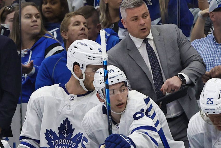 Toronto Maple Leafs head coach Sheldon Keefe talks with left wing Pierre Engvall during the third period of game three of the first round of the 2022 Stanley Cup Playoffs against the Tampa Bay Lightning at Amalie Arena in Tampa, Fla., May 6, 2022.