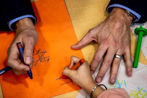 Prime Minister Justin Trudeau holds a crayon after he played, and lost, a game of tic-tac-toe against a child, following a new child care deal announcement with Ontario Premier Doug Ford (not pictured).