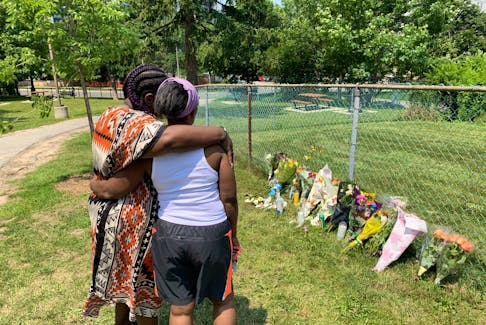 Natalie MacIntosh (left) and Ursular Francis look over a makeshift memorial for Caden Francis, 16, who was gunned down. 