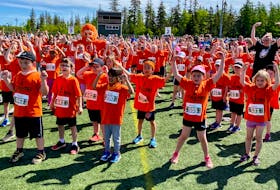 Seven-year-old Bruce Zhang, centre with orange bandana, was excited to join almost 1,000 other Cape Breton kids at the annual Doctors Nova Scotia Youth Run. Above, it was a literal sea of orange as participants gathered for warm-ups on the soccer field at the Cape Breton Health and Recreation Complex at the CBU campus on Sunday. DAVID JALA/CAPE BRETON POST