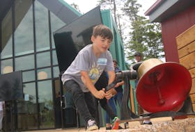 Bennett McKeage rings the bell at the end of the grand re-opening ceremonies at Brigadoon Village on June 11. The bell drives the daily activities at camp. Bennett is the son of Brigadoon Village founder Dave McKeage.