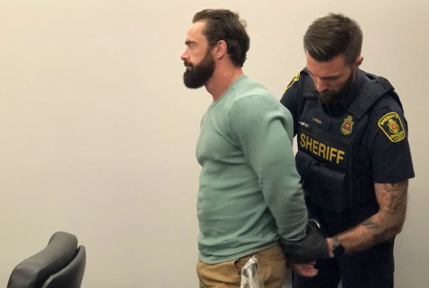 A sheriff takes former high school teacher Noel Strapp, 40, into custody following his sentencing in Provincial Court in St. John’s Tuesday, June 14 2022.