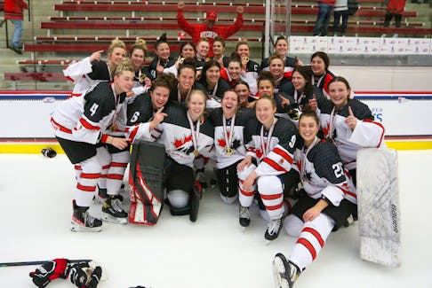 Canadian players, including Avi Adam (Wolfville) and Lucy Phillips (Upper Tantallon) pose for a photo after winning gold at the IIHF world women's Under-18 hockey championship in Madison, Wisc., on Monday night. - IIHF