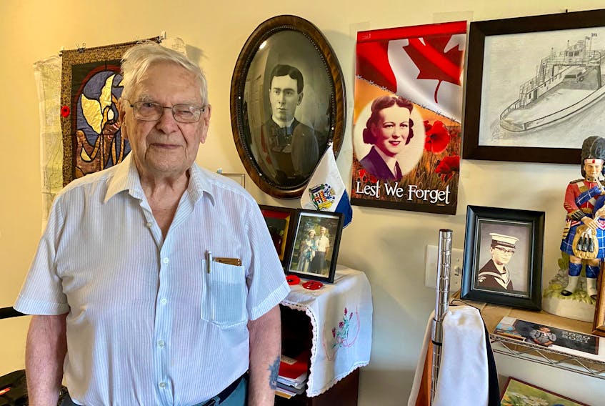 Second World War veteran Joe Burke stands in front of some photos and memorabilia in his Sydney apartment. While he saw the horrors of war, the now 98-year-old brought home mixed memories of his time overseas. He met his wife in Scotland before chancing into a meeting with four members of the Royal Family, including a 16-year-old then-Princess Elizabeth, during a visit to Windsor Castle. Burke’s first wife Helen is shown on the Lest We Forget poster. DAVID JALA/CAPE BRETON POST