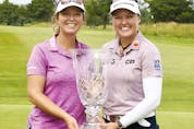  Brooke Henderson and caddie Brittany Henderson pose with the trophy after Brooke’s victory at the ShopRite Classic at Seaview Bay Course on June 12, 2022 in Galloway, New Jersey.