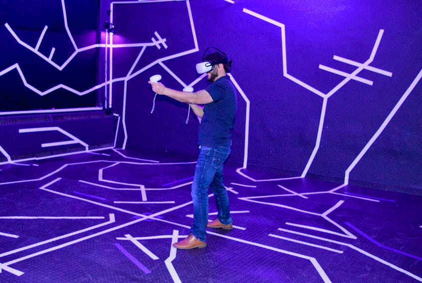 Joseph Gracie demonstrates how a player might move during a game of VR laser tag at the Soulvaria Virtual Reality and Gaming Entertainment centre in Sydney. Gracie, who launched the venture in 2017, said business is on the rise now that most COVID-era restrictions and limitations are no longer in place. DAVID JALA/CAPE BRETON POST