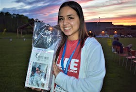 Keauna Moulaison holds up the luminary for her dad Randy, which was one of many set-up around the walking oval, during the Pictou County Relay for Life event June 11.