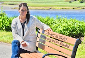 Stacey Cook sits on the memorial bench in her son Colton Cook's memory that is located next to the Milton Clock tower in Heritage Park along the north part of Water Street in Yarmouth. She says having the bench as a place to feel connected to her son is deeply meaningful. TINA COMEAU PHOTO