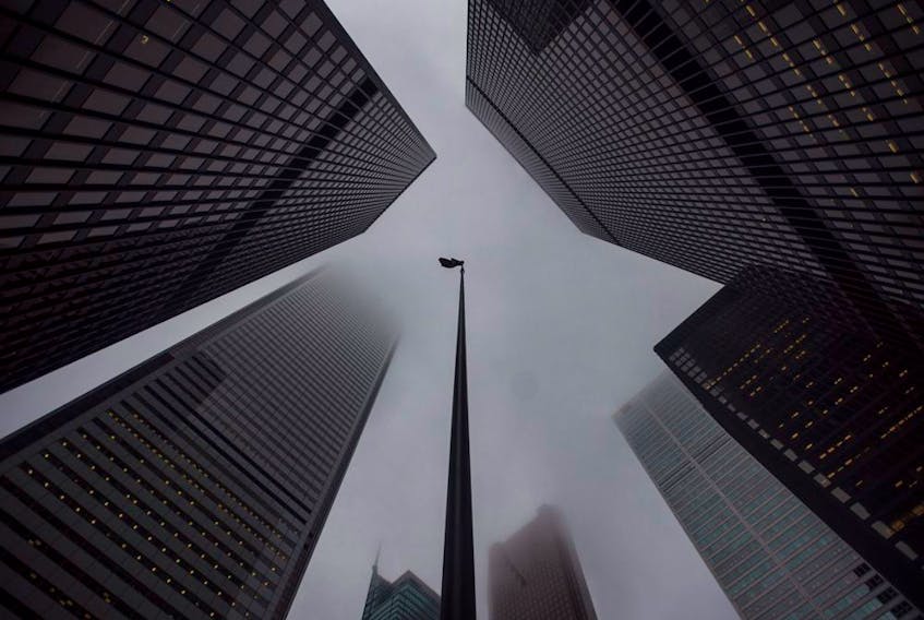 The Canadian flag blows in the wind in the heart of the financial district in Toronto.