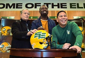 Unveiling the return to the double-E helmet design are, from left, Dan McKinnon, former assistant coach, Mookie Mitchell, former receiver and current EE Football Alumni Association president, as well as Elks president and CEO Victor Cui at Commonwealth Stadium in Edmonton on March 3, 2022.