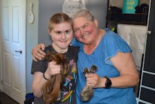 Nicola Richards, left, 13, of Summerside and her 63-year-old grandmother, Debbie Crowther of Kensington show off their new haircuts on June 16 and display the cut-off pieces that will be donated to a company that makes wigs for people who lose their hair due to health reasons. Dave Stewart • The Guardian