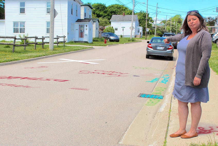 Cape Breton Regional Municipality Dist. 2 Coun. Earlene MacMullin points to some of spray-painted graffiti lining a North Sydney neighbourhood. She said phallic images, slurs against police and Swastikas cover four streets that run along the railway tracks, beginning at the train trestle on Regent Street. Chris Connors/Cape Breton Post