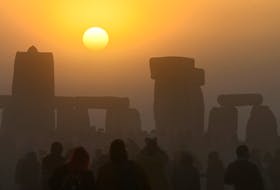 Revellers celebrate the Summer Solstice at Stonehenge stone circle near Amesbury, Britain, on Tuesday, June 21, 2022. - Toby Melville / Reuters