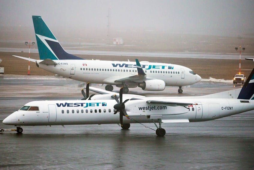 A WestJet De Havilland Q400 turboprop airplane, foreground, makes its way past a Boeing 737 on the tarmac of the Halifax Stanfield International Airport. WestJet plans to relocate its fleet of the 78-passenger planes to Western Canada. The plane is presently used on the carrier’s Sydney to/from Halifax flight. SALTWIRE FILE PHOTO