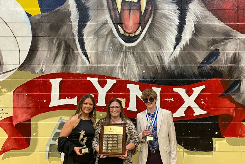 École Acadienne athletic director Melanie Richard, centre, recognizes top student athletes Delaney Martin and Oliver Grant during the school’s awards ceremony on June 9. Contributed