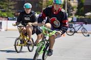 Ottawa Senators defenseman Nick Holden races Ottawa Police Superintendent Ken Bryden on kid sized bikes after giving kids from Bayshore Public School bike helmets. 