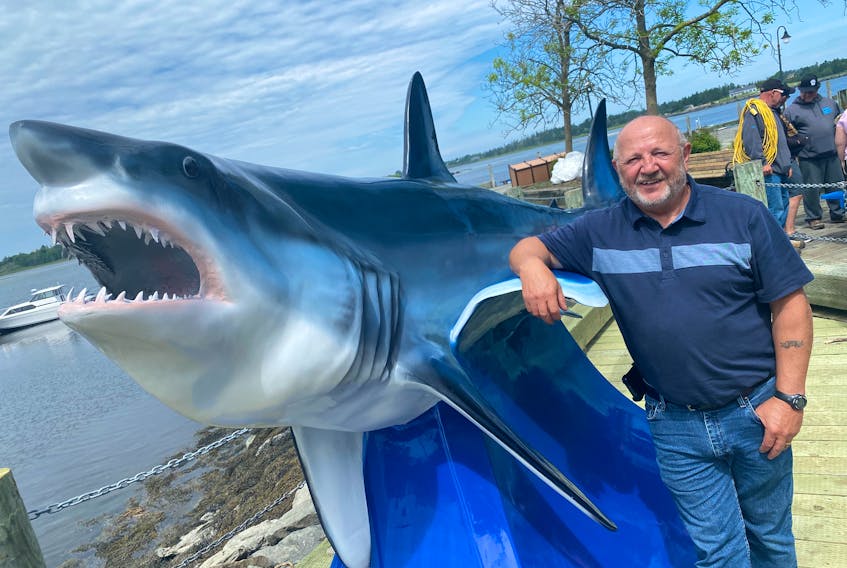 Yarmouth Shark Scramble organizer and committee member Bob Gavel stands next to a replica of the 1,084.28-pound short-fin Mako shark that was caught during the 2004 Yarmouth Shark Scramble, setting a Canadian record in the process. It was recently unveiled on Yarmouth’s waterfront. TINA COMEAU PHOTO