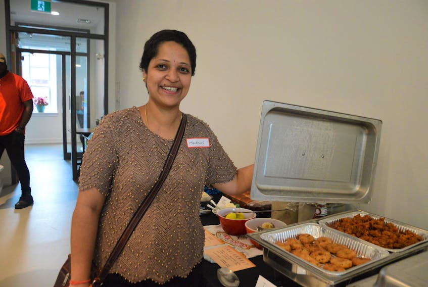 Madhuri Chintaluri shows the masala wada (Indian donuts) she made for the International Potluck hosted by the Cape Breton Island Centre for Immigration on Friday at the Eltuek Arts Centre in Sydney. The masala wada is the dish in the front which takes about three hours of preparation: two for soaking the mung dahl beans and one for making it. Chintaluri, who arrived in Canada in May, was one of about 25 people who attended the lunch that is intended to help newcomers to Cape Breton meet other people in the community. NICOLE SULLIVAN/CAPE BRETON POST