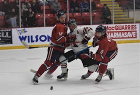 Bearcats’ forward Gavin Hart double-teamed by Valley Wildcats Philippe Casault (#4) and Keigan Casey (#14) during game seven of the Nova Scotia final.