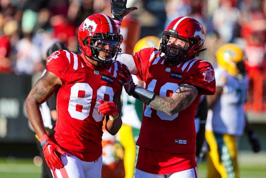 Calgary Stampeders quarterback Bo Levi Mitchell and receiver Kamar Jorden celebrate after the team scored a touchdown against the Edmonton Elks at McMahon Stadium in Calgary on Saturday, June 25, 2022. The Stampeders won 30-23.