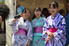 Ayane Hori, left, Manami Okura and Akari Yoneda encourage passers-by to try on a Japanese yukata – a summer kimono at the DiverseCity Multicultural Festival in Charlottetown, June 26. Alison Jenkins • The Guardian