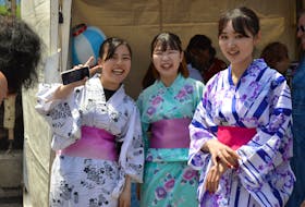 Ayane Hori, left, Manami Okura and Akari Yoneda encourage passers-by to try on a Japanese yukata – a summer kimono at the DiverseCity Multicultural Festival in Charlottetown, June 26. Alison Jenkins • The Guardian