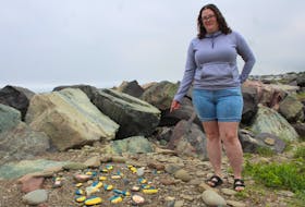 Chantal MacKay of Sydney points to a painted rock display showing support for Ukraine on Sunday at Dominion Beach. IAN NATHANSON/CAPE BRETON POST