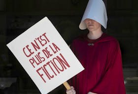 Dressed in a fictional character of the novel Handmaid's Tale, a protester takes part in a pro-choice protest outside Palais de Justice on Sunday, June 26, 2022. The protest was in response to the U.S. Supreme Court overturning Roe v. Wade on Friday.