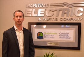 Jason Roberts, CEO and president of Maritime Electric, stands next to the company's award for sustainability June 20. Alison Jenkins * The Guardian