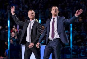 Vancouver Canucks former players Daniel Sedin and Henrik Sedin of Sweden  react during a number retirement ceremony held prior to a game between the Vancouver Canucks and Chicago Blackhawks at Rogers Arena. 